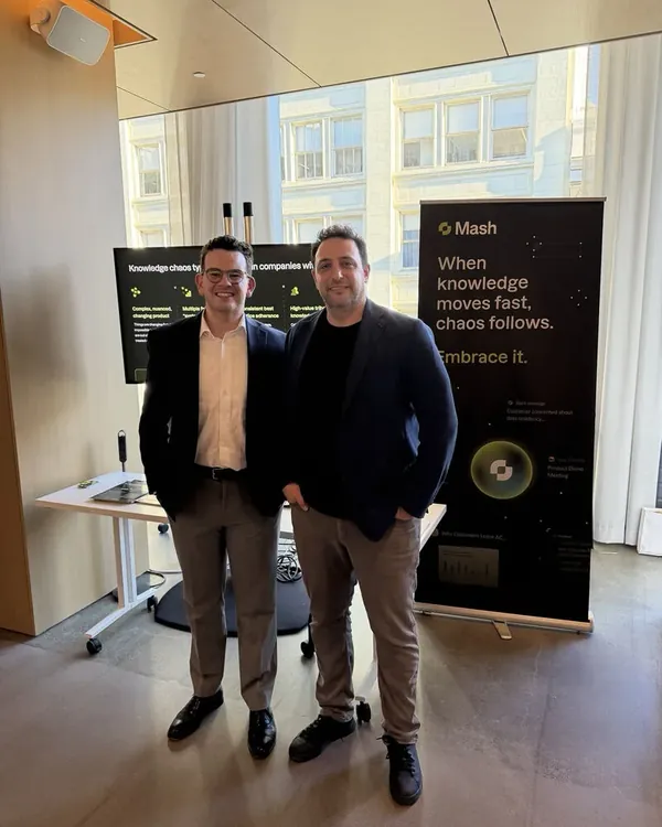 Two team members in front of the Mash banner at DemoFest SF